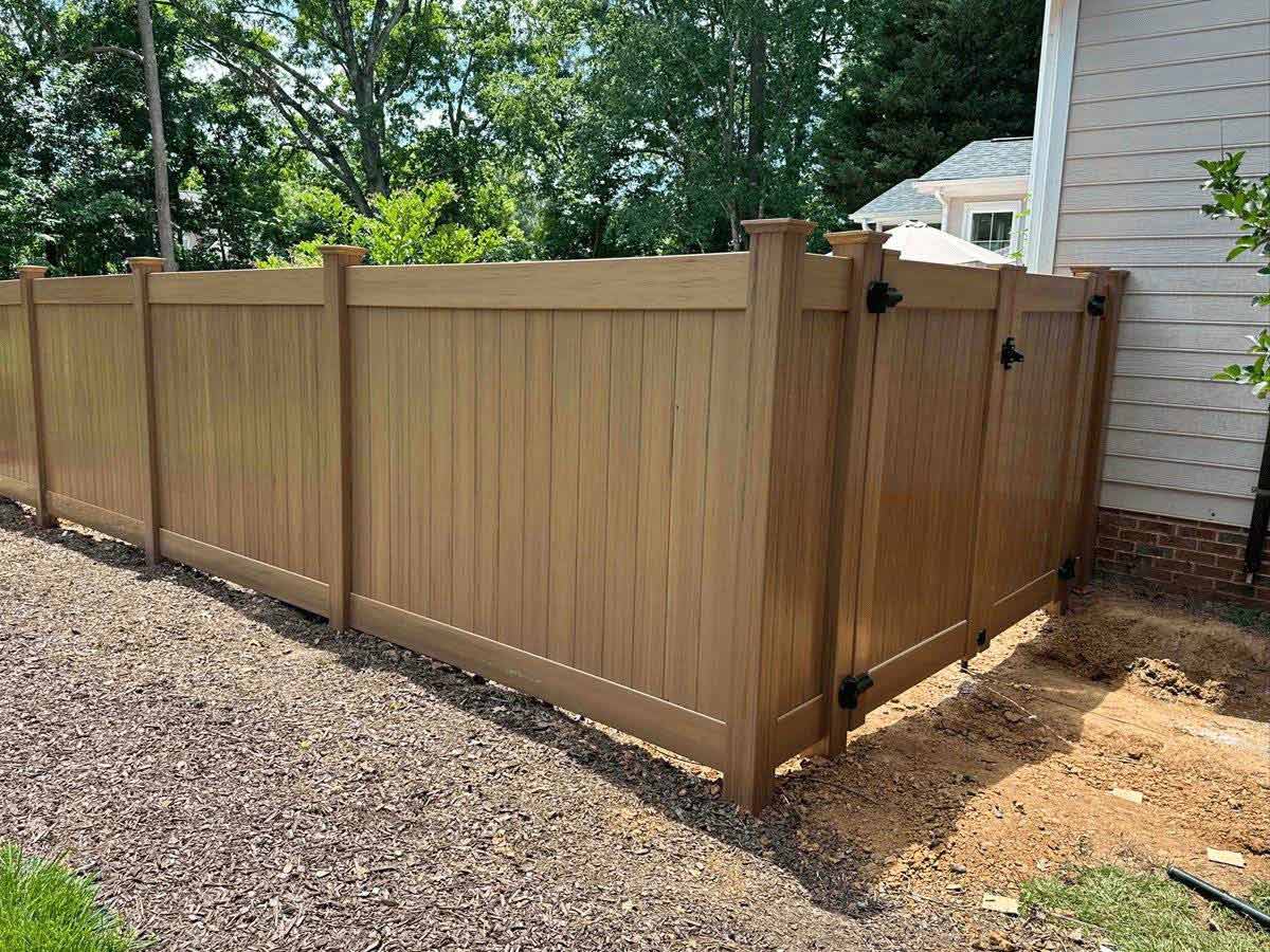 Fence with Wood style vinyl privacy fence for residential properties. in Raleigh-Durham North Carolina